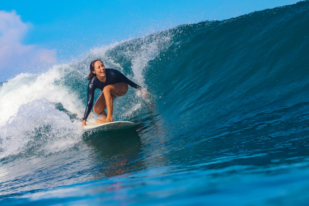 Symbolbild "Female surfer on a blue wave". Copyright: trubavink - stock.adobe.com