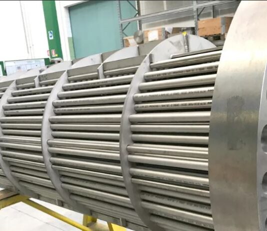 Mutares: Verkauf der Balcke-Dürr Nuklear Service Großer industrieller Wärmetauscher mit mehreren parallel angeordneten Metallrohren. Die zylindrische Struktur hat eine runde Endplatte mit vielen Löchern, durch die die Rohre hindurchgehen.