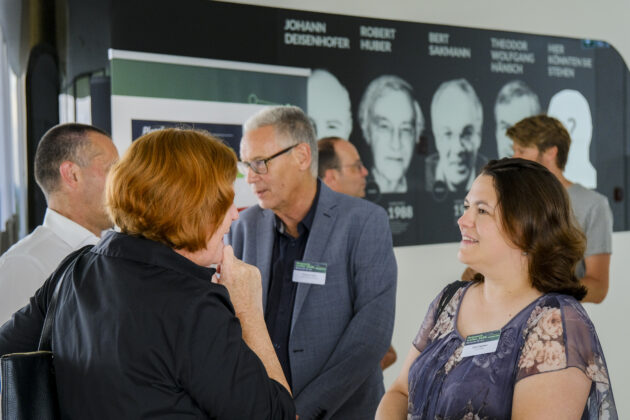 Menschen in Business-Casual-Kleidung unterhalten sich auf einem Firmen Event.