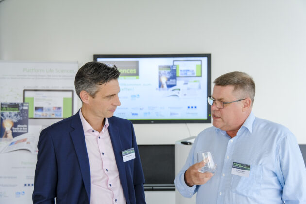 Menschen in Business-Casual-Kleidung unterhalten sich auf einem Firmen Event.