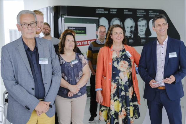Menschen in Business-Casual-Kleidung unterhalten sich auf einem Firmen Event.
