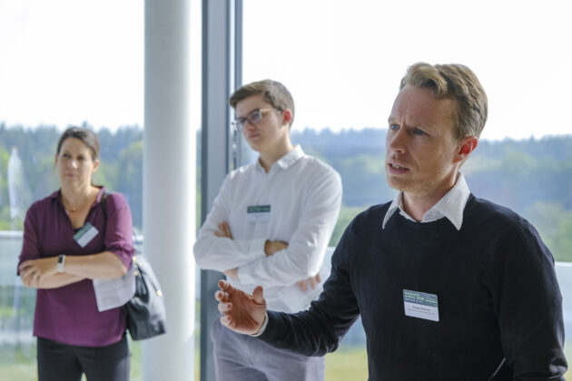 Menschen in Business-Casual-Kleidung unterhalten sich auf einem Firmen Event.