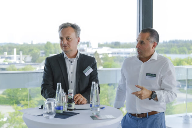 Menschen in Business-Casual-Kleidung unterhalten sich auf einem Firmen Event.