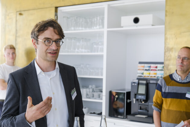 Menschen in Business-Casual-Kleidung unterhalten sich auf einem Firmen Event.