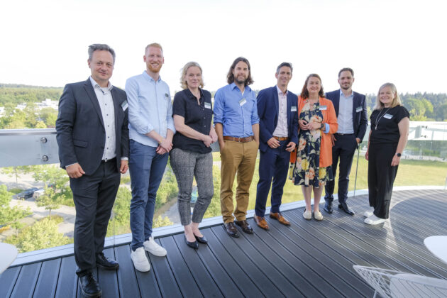 Menschen in Business-Casual-Kleidung unterhalten sich auf einem Firmen Event.