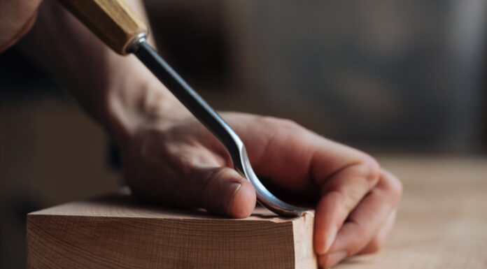 Symbolbild "Carve-out". (Wood carving, the master's hands work with a wooden surface, a professional does wood crafts.) Copyright: Александр Татаев - stock.adobe.com