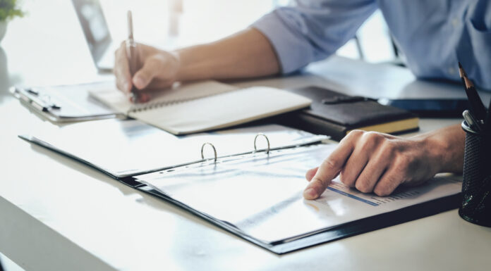 Symbolbild "Internal Audit" (Examining the financial budget, a male auditor is pointing to a file to summarize the company's irregular financial budget). Copyright: Jirapong - stock.adobe.com