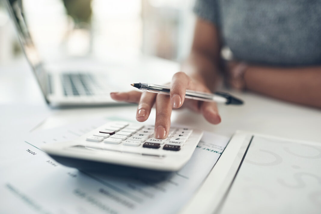 Finance planning, budget or savings manager calculating expenses, taxes or company profits with laptop, paperwork or calculator. Closeup hands of female financial leader checking office staff ... Copyright: N Felix/peopleimages.com - stock.adobe.com