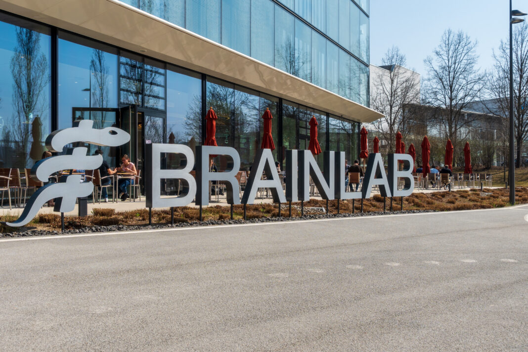 Brainlab lettering in front of the headquarters in Munich Riem with blue sky and sunshine. Copyright: Olaf Gedanitz - stock.adobe.com
