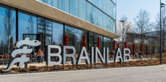 Brainlab lettering in front of the headquarters in Munich Riem with blue sky and sunshine. Copyright: Olaf Gedanitz - stock.adobe.com
