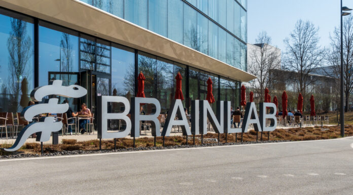 Brainlab lettering in front of the headquarters in Munich Riem with blue sky and sunshine. Copyright: Olaf Gedanitz - stock.adobe.com