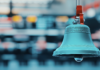 A photo image of a traditional stock market bell symbolizing the opening or closing of a trading day on a busy stock exchange floor. Copyright: taweesak - stock.adobe.com