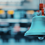 A photo image of a traditional stock market bell symbolizing the opening or closing of a trading day on a busy stock exchange floor. Copyright: taweesak - stock.adobe.com