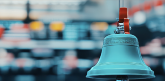 A photo image of a traditional stock market bell symbolizing the opening or closing of a trading day on a busy stock exchange floor. Copyright: taweesak - stock.adobe.com