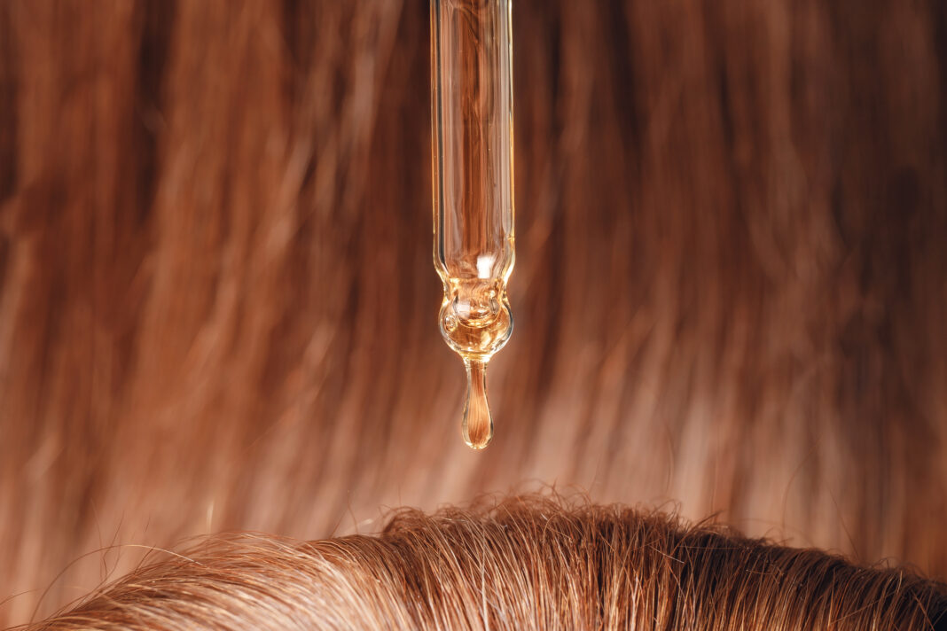 Symbolbild. Close-up drop of essence to restore and recovery hair is applied to head bulbs. Copyright: Parilov - stock.adobe.com
