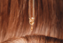 Symbolbild. Close-up drop of essence to restore and recovery hair is applied to head bulbs. Copyright: Parilov - stock.adobe.com