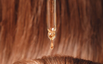 Symbolbild. Close-up drop of essence to restore and recovery hair is applied to head bulbs. Copyright: Parilov - stock.adobe.com