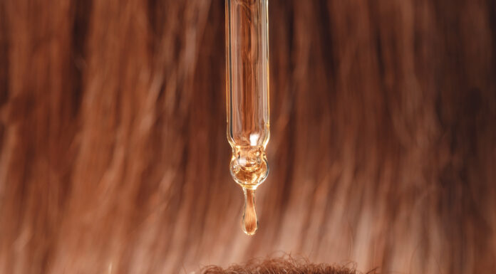 Symbolbild. Close-up drop of essence to restore and recovery hair is applied to head bulbs. Copyright: Parilov - stock.adobe.com