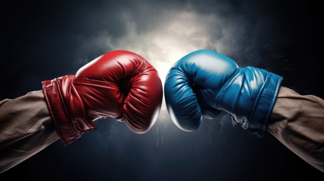 Symbolbild. Closeup two man hands in red and blue boxing gloves hitting each other on isolated dark misty background. Copyright: GulArt - stock.adobe.com