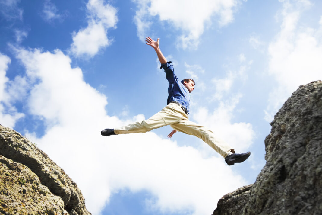 Symbolbild. Businessman jumping over the mountains, business concept. Copyright: clarusvisus - stock.adobe.com