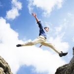 Symbolbild. Businessman jumping over the mountains, business concept. Copyright: clarusvisus - stock.adobe.com