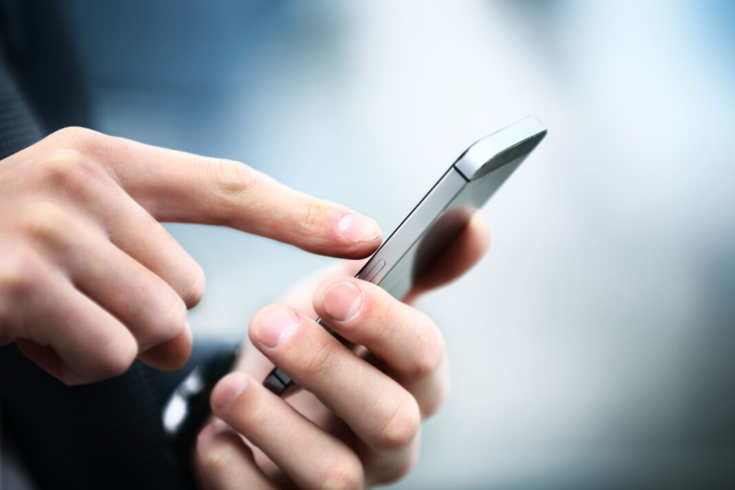 Symbolbild. Close up of a man using mobile smart phone. Copyright: PhotoStar - stock.adobe.com