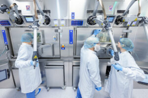 ITM-Mitarbeitende bei der Arbeit mit Manipulatoren in Prozesszelle. Copyright: ITM Isotope Technologies Munich SE