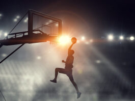 Silhouette of basketball player at stadium throwing ball in basket. Copyright: Mixed media - stock.adobe.com
