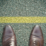 Der Preis des Zögerns: Insights aus kommendem EY-Report Symbolbild. (concept pieds sur la route et ligne jaune.) Copyright: pixarno - stock.adobe.com