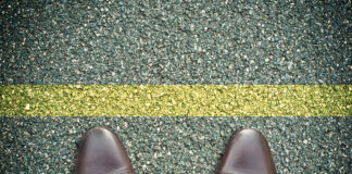 Symbolbild. (concept pieds sur la route et ligne jaune.) Copyright: pixarno - stock.adobe.com