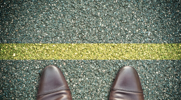 Symbolbild. (concept pieds sur la route et ligne jaune.) Copyright: pixarno - stock.adobe.com