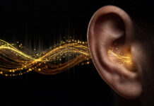 Symbolbild. Human ear with glowing golden sound waves and light particles representing hearing, auditory perception, sound frequency, or hearing aid technology. Copyright: Vivid Pixel - stock.adobe.com