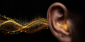 Symbolbild. Human ear with glowing golden sound waves and light particles representing hearing, auditory perception, sound frequency, or hearing aid technology. Copyright: Vivid Pixel - stock.adobe.com