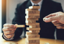 Symbolbild "Jenga". Strategic thinking and risk by business people pulls wooden blocks from the group. Cppyright: wutzkoh - stock.adobe.com