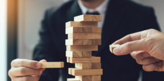 Symbolbild "Jenga". Strategic thinking and risk by business people pulls wooden blocks from the group. Cppyright: wutzkoh - stock.adobe.com