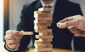 Biotech 2025: Resilient an der Oberfläche, fragil im Fundament Symbolbild "Jenga". Strategic thinking and risk by business people pulls wooden blocks from the group. Cppyright: wutzkoh - stock.adobe.com