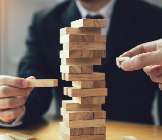 Biotech 2025: Resilient an der Oberfläche, fragil im Fundament Symbolbild "Jenga". Strategic thinking and risk by business people pulls wooden blocks from the group. Cppyright: wutzkoh - stock.adobe.com