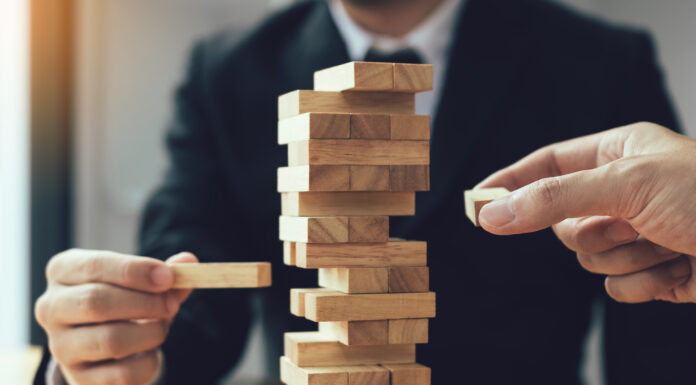 Symbolbild "Jenga". Strategic thinking and risk by business people pulls wooden blocks from the group. Cppyright: wutzkoh - stock.adobe.com