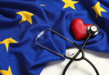 Stethoscope, red heart and flag of European Union on white wooden table. Copyright: New Africa - stock.adobe.com
